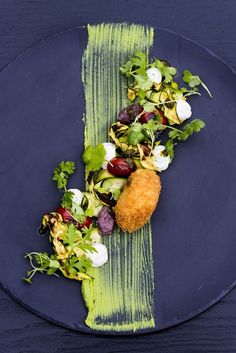 a blue plate topped with food on top of a wooden table