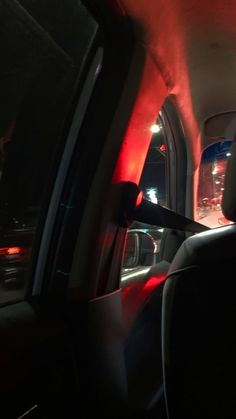 the interior of a car with red light coming from it's windows and lights on