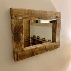 a wooden mirror hanging on the wall