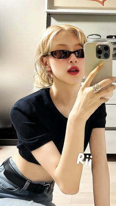 a woman taking a selfie with her cell phone in front of her, wearing sunglasses and sitting on the floor