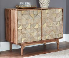 a wooden cabinet sitting on top of a hard wood floor next to a white rug