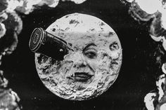 a black and white photo of a moon with a telescope