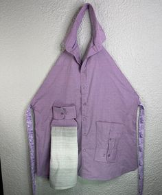 a purple shirt hanging on the wall with two ties attached to it's back