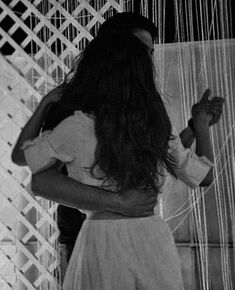 a woman standing in front of a weaving machine with her hands on the back of her head