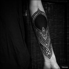 a black and white photo of a person's arm with a tattoo on it