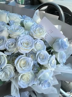 a bouquet of white roses sitting on top of a table