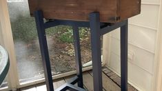 a wooden table sitting on top of a hard wood floor next to a glass door