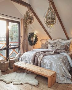 an attic bedroom with wooden beams and white bedding, pillows and throw rugs