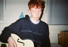 a young man is playing an electric guitar