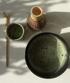 a table with two bowls, a bamboo brush and some other items on top of it