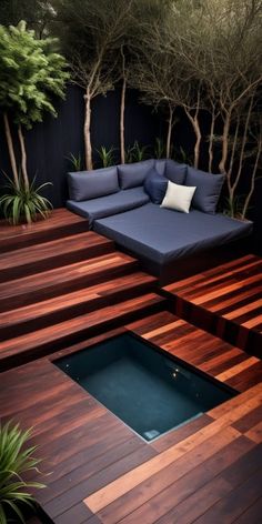 an outdoor living area with wooden decking and blue cushions