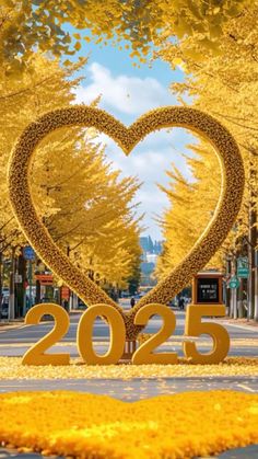 a heart - shaped sculpture in the middle of a street surrounded by trees and yellow leaves