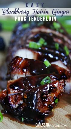 an image of pork tendereon on a cutting board with blueberries and green onions