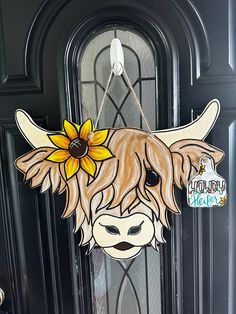 the door is decorated with a cow's head and sunflowers on it