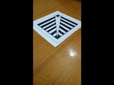 a wooden table topped with a white and black square floor drain cover on top of a hard wood floor