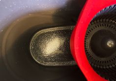 the inside of a red and black blow dryer on top of a white table