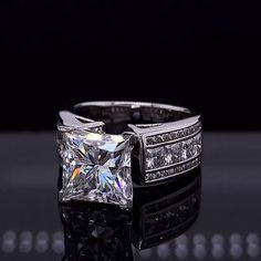 a white gold ring with a princess cut diamond and channeled diamonds on the sides