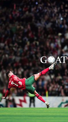 a man kicking a soccer ball on top of a field in front of a crowd