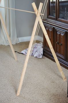 a pair of wooden clothes racks sitting on top of a carpeted floor