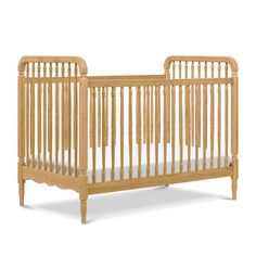 a wooden crib with white sheets on the bottom and side rails, against a white background