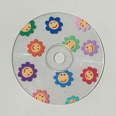 a cd with smiley faces and flowers on it