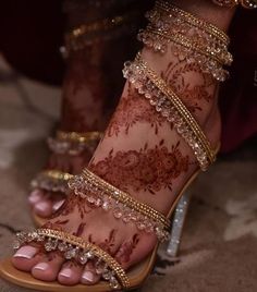 a woman's feet with hennap and gold jewelry