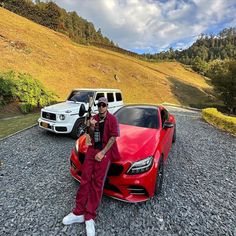 a man standing next to a red sports car