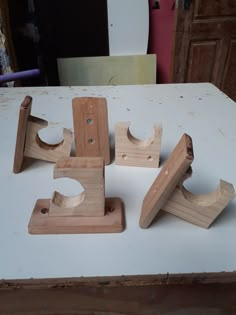 several pieces of wood sitting on top of a white table next to a pair of scissors