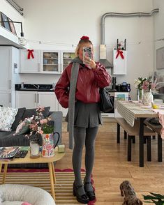 a woman taking a selfie with her cell phone in a room full of furniture