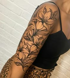 a woman's arm with flowers and leaves tattooed on the side of her body