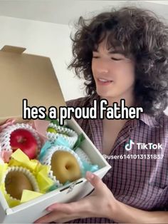 a woman holding a box with donuts in it and the caption reads, he's a proud father