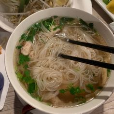 a bowl filled with noodles and vegetables on top of a table