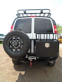 the back end of a white truck with black tires and an atv rack on it