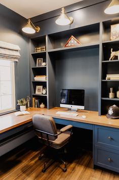 a home office with built - in shelving and desk