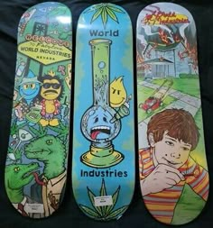 three skateboards with cartoon images on them are lined up next to each other in front of a black background