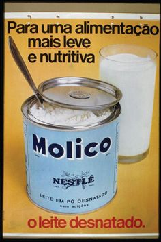 a can of molcico with a spoon in it next to a glass of milk