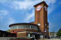 a large brick building with a clock on the side of it's face in front of a blue sky