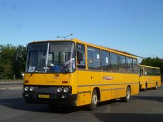 two yellow buses are parked in a parking lot