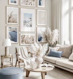 a living room filled with white furniture and pictures on the wall above it's coffee table