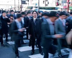 a group of people walking across a street next to each other on crosswalks