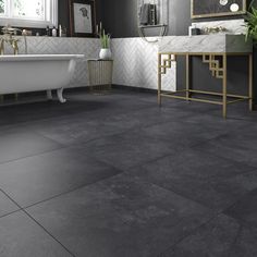 a bathroom with black and white tile flooring next to a bathtub, sink and mirror