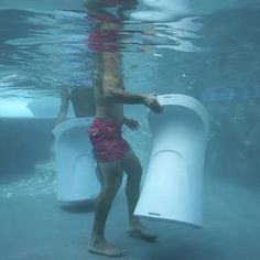 a man standing in the water next to an object