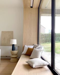 a living room filled with lots of furniture next to a large glass window on the wall