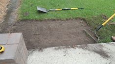 a man laying on the ground with a shovel and rake in his hand next to a hole