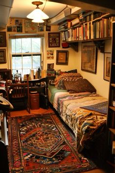 a bedroom with a bed, desk and bookshelf filled with lots of books