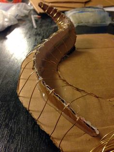 a piece of cardboard that has been wrapped in wire and is sitting on a table