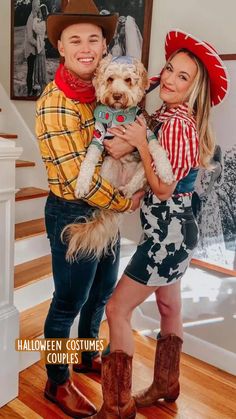 a man and woman holding a dog in their arms while standing next to each other