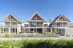 a row of houses sitting next to each other on top of a lush green field