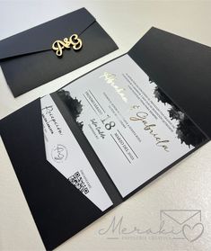 a black and white wedding card with gold lettering on it, next to an envelope