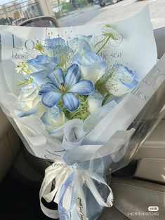 a bouquet of blue and white flowers sitting in the back seat of a car